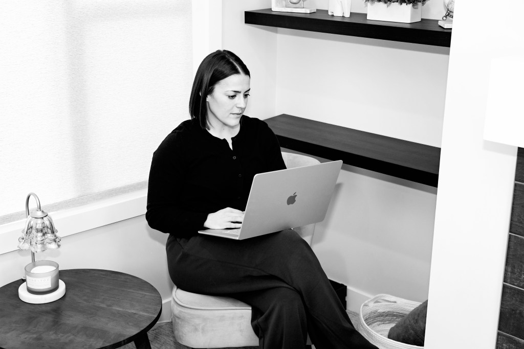 Coach working on a laptop to plan a client's coaching program