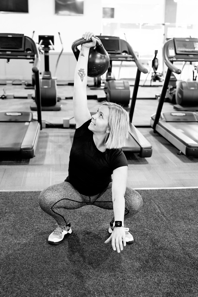 Kaylee Bennett demonstrating a kettlebell overhead squat in the gym